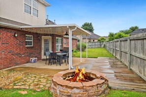 Out back, enjoy our six-top dining table, gas grill, fire pit and string lights.