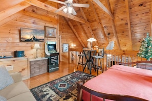 The upstairs loft includes an arcade game, large Smart TV, additional seating and sleeping space.