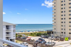 The top-floor partially covered deck with expansive ocean views