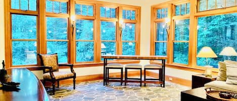 Tavern room with sleeper sofa, radiant flooring, 80” TV & bar table.