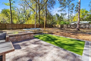 Backyard built for fun—putting course and fire pit vibes.