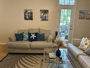 Living room with luxury vinyl floors, transom windows and bonus chair with single pull out bed