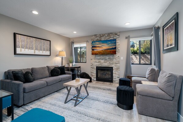 Living room (Queen sleeper, gas fireplace, corner desk, heated floors & 50" TV)