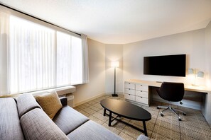 Spacious living room with a sofa bed and a workspace.