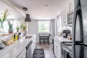 Guest Favorite Airbnb
Complete Culinary Haven Step into our kitchen, equipped with a Frigidaire refrigerator, electric stove, single oven, microwave, and dishwasher. From pots and pans to cooking basics, everything you need for cooking is at your fingertips. Enhance your dining experience with our elegant dining table and wine glasses, adding a touch of sophistication