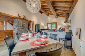 Une cuisine moderne ouverte sur le salon vous invite à cuisiner avec sa table en chêne blanc dressée pour 10 personnes