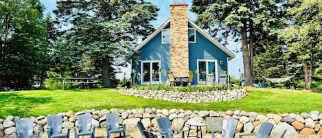 The house features a sand beach, fire pit, and cement patio over-looking Huron