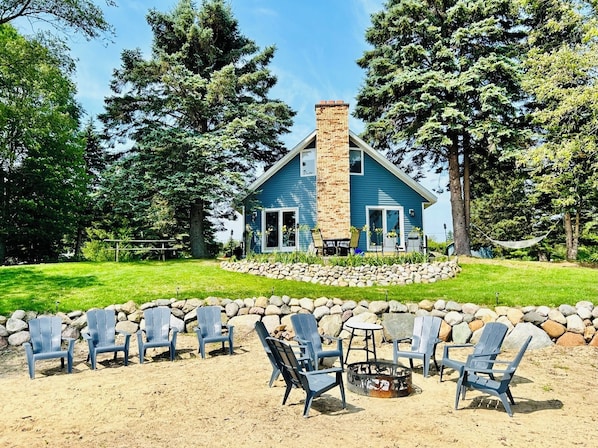 The house features a sand beach, fire pit, and cement patio over-looking Huron