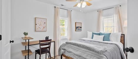 Master bedroom with queen bed, ceiling fan, closet space, desk and ensuite full bathroom.