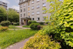 A view of the building surrounded by a lush green garden, creating a peaceful and inviting atmosphere.
