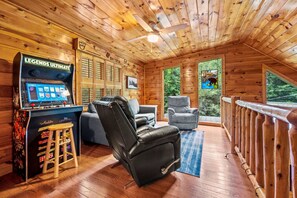 Upstairs lounge area includes comfortable leather recliner, sofa, and arcade games.