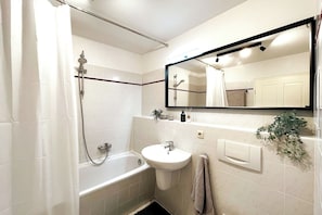 Helles Bad mit Badewanne und großem Spiegel