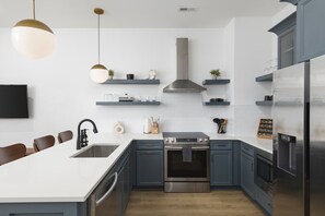 Fully-stocked kitchen with high-end appliances and seating for 4 at the kitchen counter.