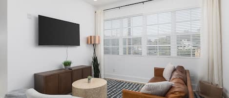 Our cozy living room is a great space to relax, with a comfortable leather couch, lots of natural light, and a Smart TV with all the streaming apps.