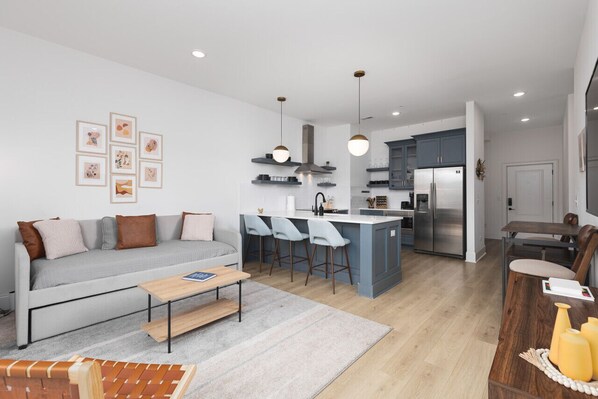 Open floor plan with lots of natural light, Smart TV, and seating at the kitchen counter. There is also a separate high-top dining table with seating for 4.