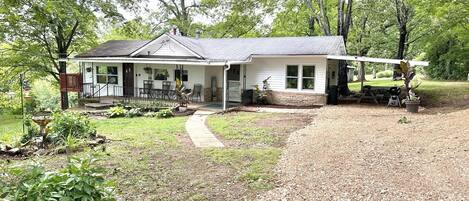 Deck, covered porch, covered outdoor dining area, flowerbeds & yard