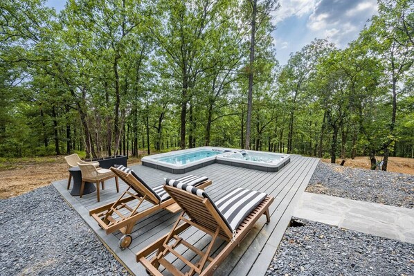 Outdoor Oasis: Unwind in the swim spa surrounded by serene forest views and comfy lounge chairs!