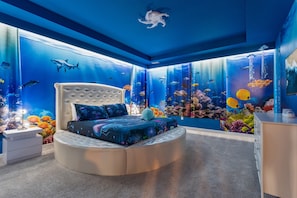 Dive into comfort in our 'Under the Sea' king room. Custom ocean decor, luxurious bedding, and an ensuite bathroom await.