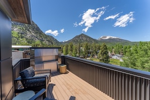 Private balcony #3 offering panoramic mountain views, seating and a gas fireplace.