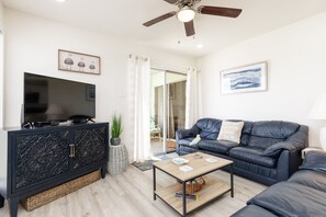 Living area with flat screen TV to enjoy and comfy furniture to relax on with easy access to the private patio space