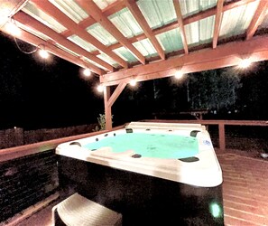 Hot tub and covered deck with plenty of lighting for nighttime use.