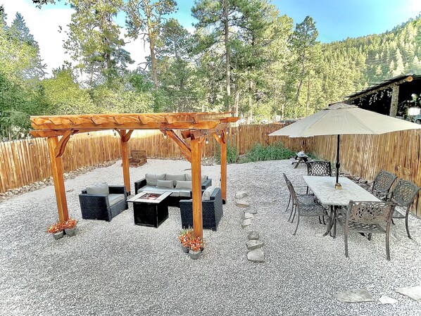 Large, fenced private backyard with dining area and pergola with seating more!