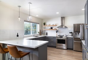 The designer kitchen features plenty of counter space and bar top seating.
