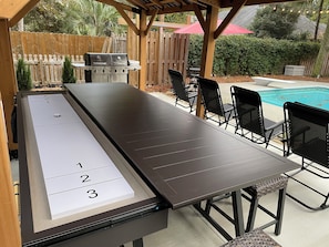 Shuffleboard table with sliding top for dining or a back yard buffet.