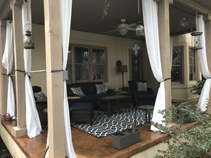 Covered rear porch with fan, soundbar, two chairs and love seat