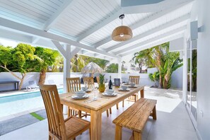 A covered outdoor space with dining perfect to enjoy dining alfresco with the beautiful Aruban weather.