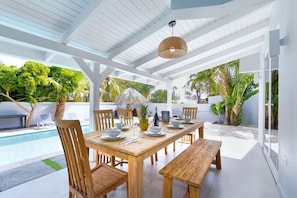 A covered outdoor space with dining 