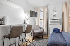 Modern studio seating area with two versatile convertible chairs and a comfy couch.