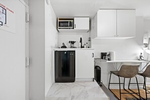 Compact kitchenette with modern appliances and a cozy two-seater dining