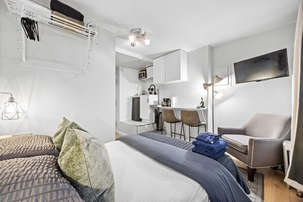 The minimalist studio features a comfortable double bed with soft textures
