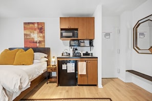 Modern kitchenette with a stovetop, microwave, and ample storage space