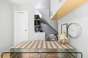 A closer look at the dining area, highlighting the glass table, chairs, and surrounding decor.