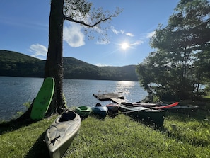 Boat dock with kayaks seen and 2 are tandem. 