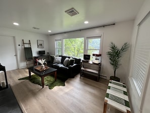 Living Room with sweeping lake views, office desk with monitor, pull out sofa.