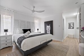 Relax in the spacious primary bedroom, offering a king-size bed with peaceful views and soft natural light.