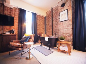 Cozy chair and bath in an industrial-chic space.