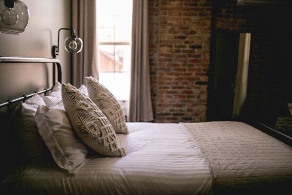 Sleep in ultimate comfort on our Queen Bed, adorned with luxurious linens for a restful, indulgent experience.