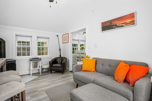 Living room serves as multipurpose space with bar and stools as well as comfy chair near the heating source stove,