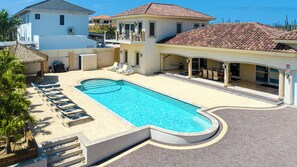Enjoy the lap pool of this Villa with multiple chairs for guests to lie on and with a gazebo for a nice shade on a sunny day
