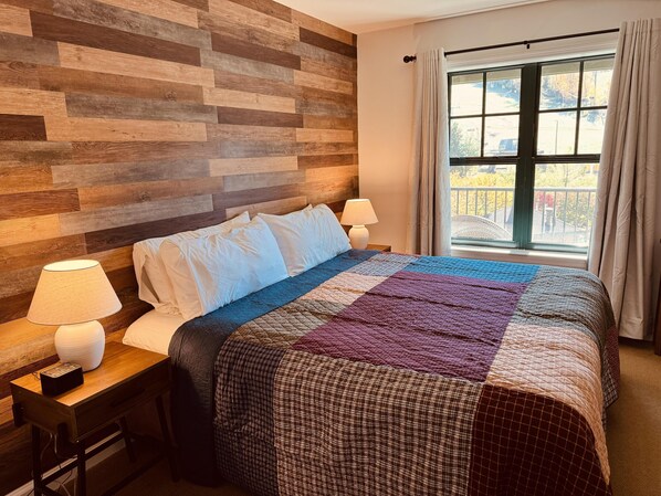 Newly decorated bedroom with king bed and mtn views of the slopes. New faux wood walls, designer quilt, lamps, night stands, makes this BR shine!