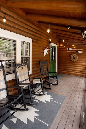 Four wood rocking chairs, log side tables, string lights, ceiling mounted heater