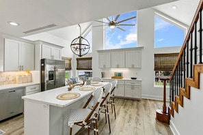 Bright, modern kitchen with high ceilings, chic decor, and ample natural light!