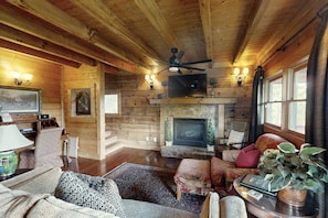 Cozy up in this living room oasis featuring a seasonal gas fireplace, a stylish desk, and comfortable seating for relaxing and unwinding.