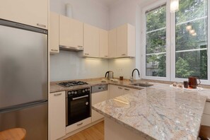 Kitchenette with oven and refrigerator. 