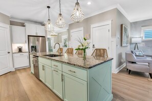 Kitchen island has ample seating and beautiful accent paint.