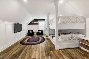 Bunk room is ideal for kids, teens, or adults with 4 queen sized beds, flat screen tv, and ample space to spread out.